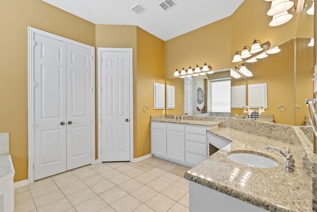 2609 Green Oak Dr, Carrollton, TX 75010 - bathroom featuring a closet, two vanities, baseboards, and tile patterned floors