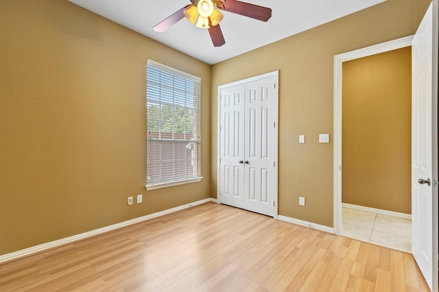 2609 Green Oak Dr, Carrollton, TX 75010 - unfurnished bedroom featuring light wood-style flooring, a closet, baseboards, and ceiling fan