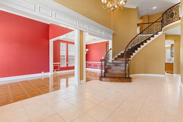 2609 Green Oak Dr, Carrollton, TX 75010 - tiled foyer featuring a high ceiling, baseboards, a chandelier, stairs, and crown molding