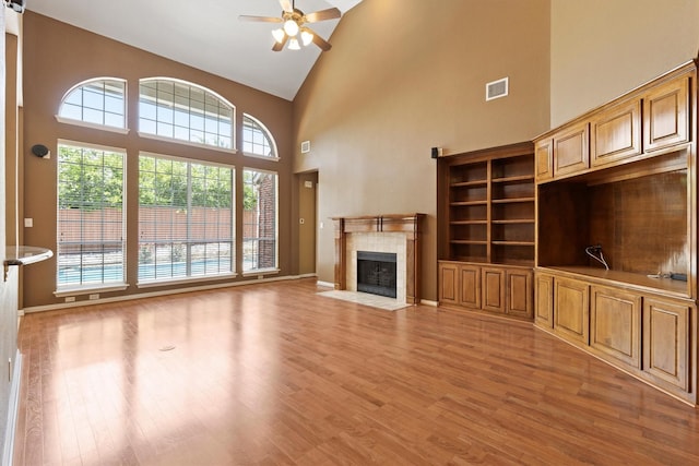 2609 Green Oak Dr, Carrollton, TX 75010 - unfurnished living room featuring high vaulted ceiling, ceiling fan, a fireplace, light wood-style flooring, and baseboards