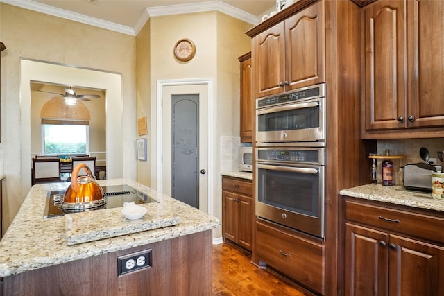 7300 Bishop Ct, Fort Worth, TX 76179 - kitchen with double oven, black electric cooktop, tasteful backsplash, light stone countertops, and dark wood-type flooring