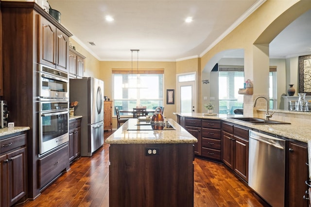 7300 Bishop Ct, Fort Worth, TX 76179 - kitchen featuring appliances with stainless steel finishes, a sink, arched walkways, a center island, and dark wood-style flooring