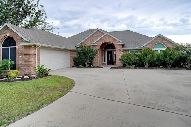 7300 Bishop Ct, Fort Worth, TX 76179 - view of front facade with brick siding, concrete driveway, roof with shingles, and a garage
