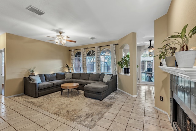 533 Cameron Ln, Allen, TX 75002 - living area featuring a ceiling fan, a tiled fireplace, light tile patterned floors, and healthy amount of natural light