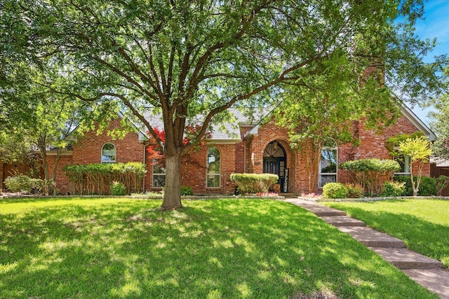 view of front of home with a front yard and brick siding
