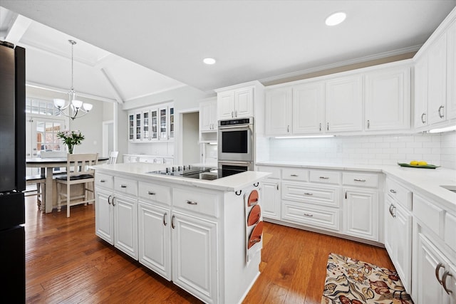 kitchen featuring black appliances, wood finished floors, recessed lighting, white cabinetry, and light countertops
