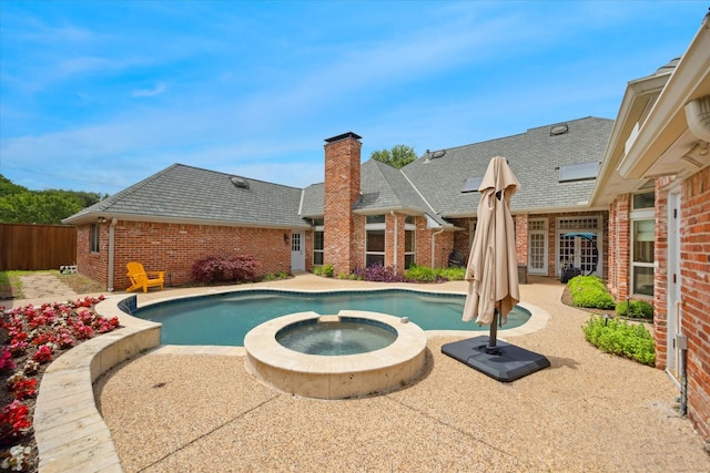 view of pool featuring a patio area, a pool with connected hot tub, and fence