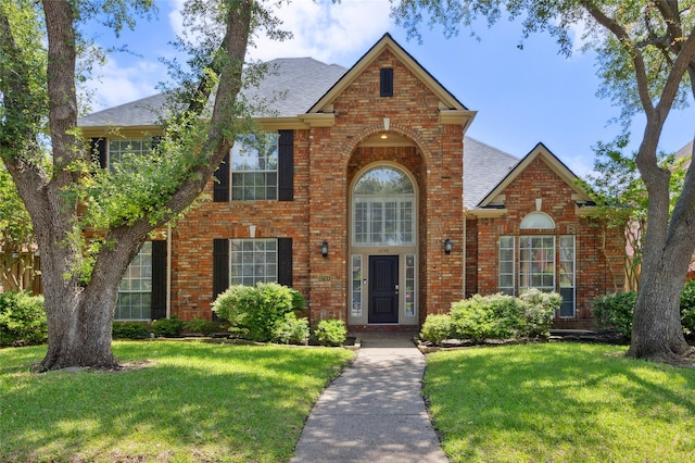 6748 Bastille Dr, Plano, TX 75024 - traditional home featuring brick siding, a shingled roof, and a front yard