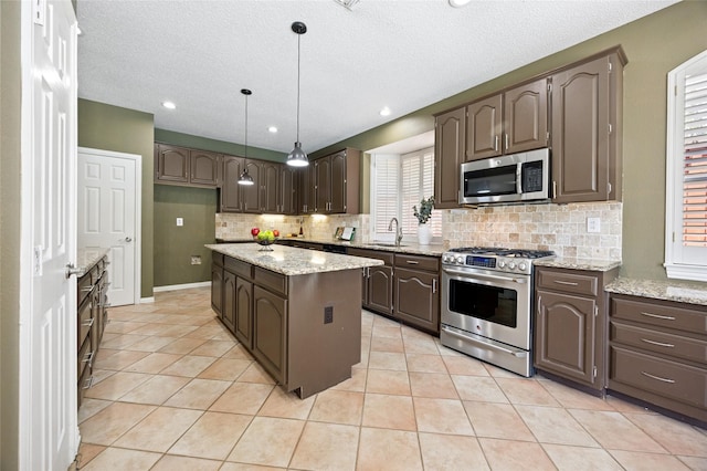 6748 Bastille Dr, Plano, TX 75024 - kitchen with stainless steel appliances, a sink, dark brown cabinets, backsplash, and a kitchen island