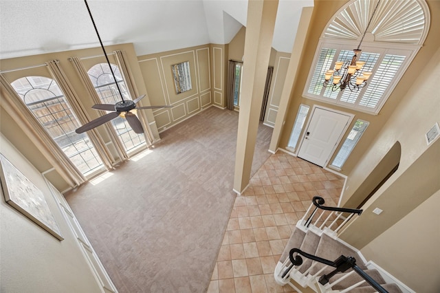 6748 Bastille Dr, Plano, TX 75024 - entryway featuring a chandelier, a decorative wall, a high ceiling, light carpet, and light tile patterned floors