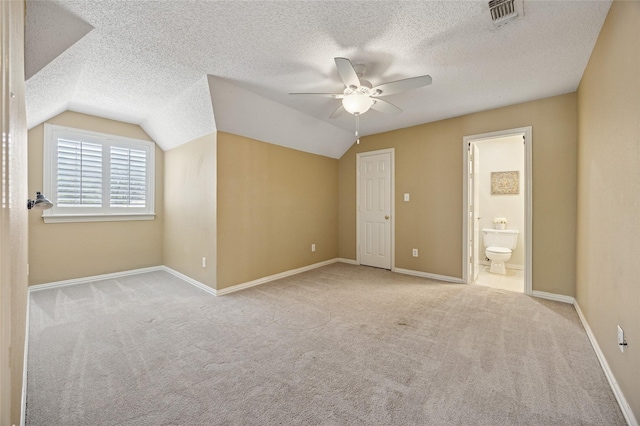 6748 Bastille Dr, Plano, TX 75024 - unfurnished bedroom featuring carpet floors, lofted ceiling, a textured ceiling, connected bathroom, and baseboards