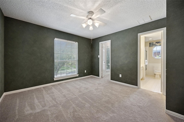 6748 Bastille Dr, Plano, TX 75024 - unfurnished bedroom with carpet flooring, a textured ceiling, ensuite bathroom, a ceiling fan, and baseboards