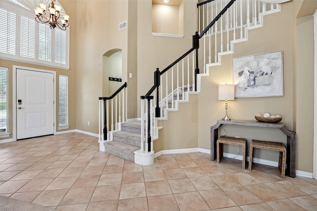 6748 Bastille Dr, Plano, TX 75024 - entryway with a high ceiling, light tile patterned floors, stairs, a chandelier, and baseboards