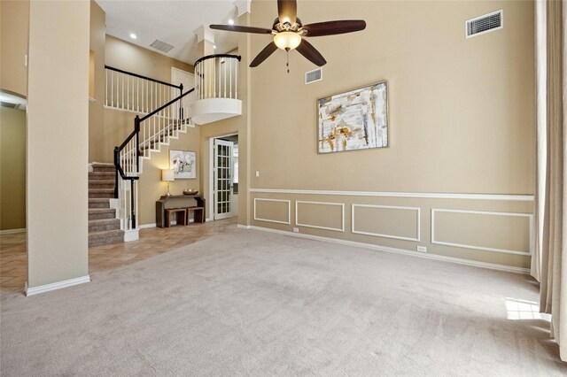 6748 Bastille Dr, Plano, TX 75024 - unfurnished living room featuring carpet flooring, ceiling fan, stairs, a high ceiling, and baseboards