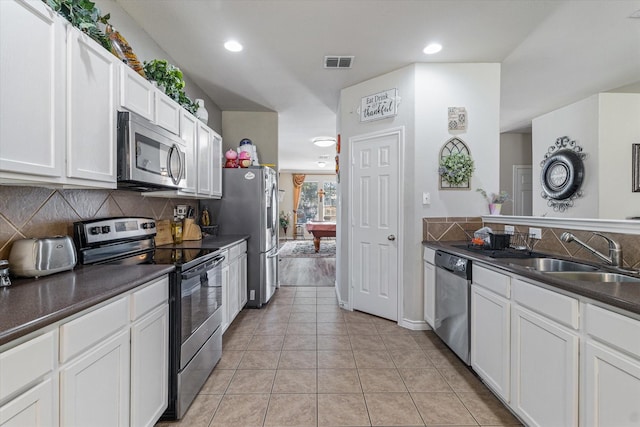 503 Sundrop Dr, Fate, TX 75132 - kitchen with appliances with stainless steel finishes, dark countertops, a sink, tasteful backsplash, and recessed lighting