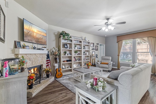 503 Sundrop Dr, Fate, TX 75132 - living room featuring dark wood-style floors, a stone fireplace, and a ceiling fan
