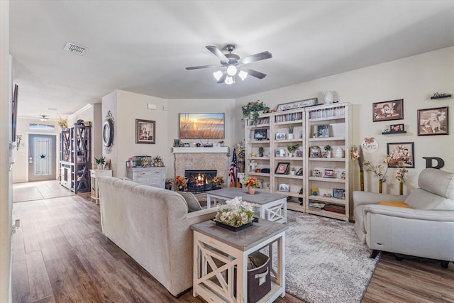 503 Sundrop Dr, Fate, TX 75132 - living room featuring a tiled fireplace, a ceiling fan, and wood finished floors