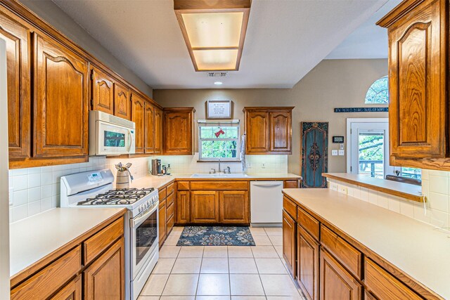 356 Old Justin Rd, Argyle, TX 76226 - kitchen with white appliances, a sink, brown cabinetry, backsplash, and light countertops