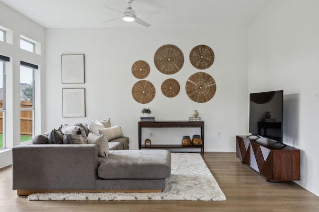 12306 Ark Rd, Frisco, TX 75035 - living area with a ceiling fan, wood finished floors, a towering ceiling, and baseboards