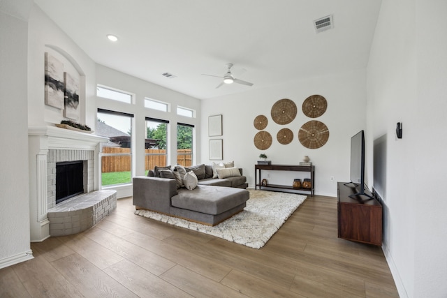 12306 Ark Rd, Frisco, TX 75035 - living room with ceiling fan, wood finished floors, a fireplace, baseboards, and a high ceiling