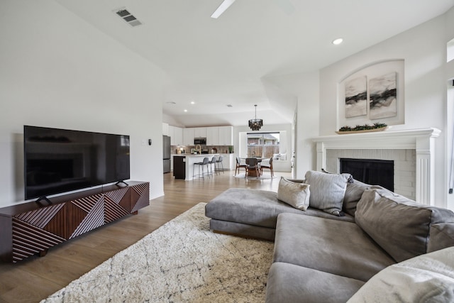 12306 Ark Rd, Frisco, TX 75035 - living area featuring wood finished floors, vaulted ceiling, recessed lighting, and a brick fireplace