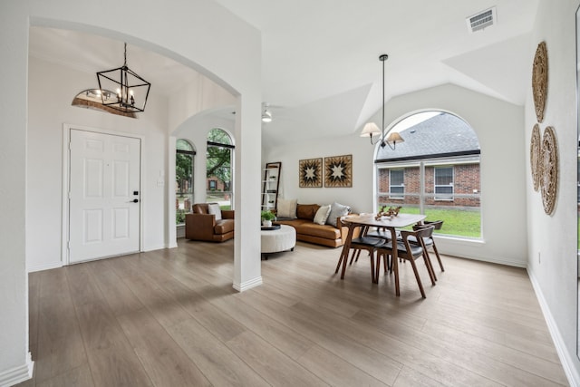 12306 Ark Rd, Frisco, TX 75035 - foyer entrance featuring a chandelier, arched walkways, vaulted ceiling, wood finished floors, and baseboards