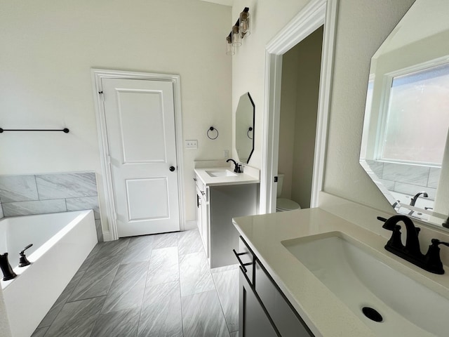 full bath featuring two vanities, a bath, and toilet