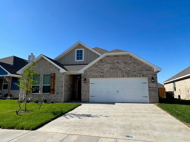 view of front of property with board and batten siding, driveway, an attached garage, a front yard, and brick siding