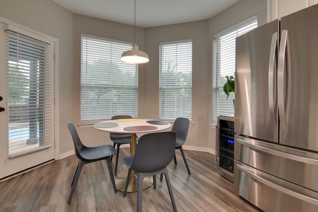dining space with wood finished floors, baseboards, and wine cooler