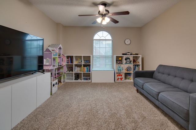 living room featuring carpet flooring, a textured ceiling, and ceiling fan