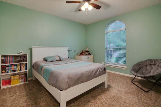 bedroom with carpet, a textured ceiling, baseboards, and a ceiling fan