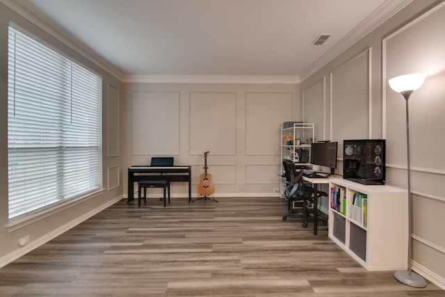 office space with a decorative wall, wood finished floors, and crown molding
