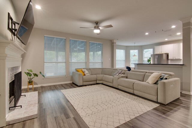 living room with ceiling fan, baseboards, a fireplace with raised hearth, recessed lighting, and dark wood-style floors