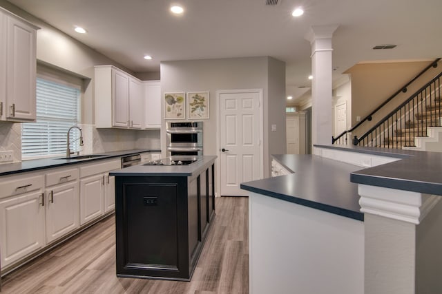 kitchen featuring a sink, dark countertops, a kitchen island, backsplash, and recessed lighting