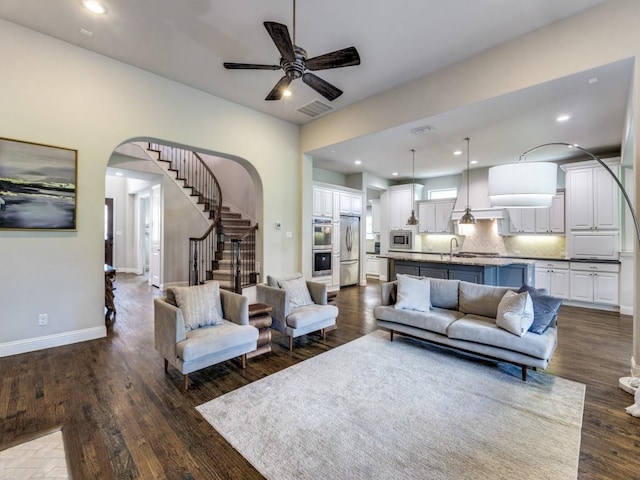 4400 Bristleleaf Ln, Prosper, TX 75078 - living area featuring ceiling fan, dark wood finished floors, arched walkways, stairway, and baseboards