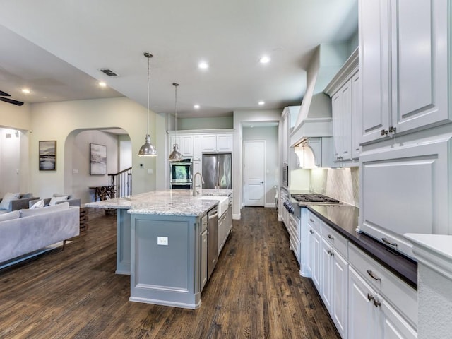 4400 Bristleleaf Ln, Prosper, TX 75078 - kitchen with open floor plan, arched walkways, stainless steel appliances, dark wood-type flooring, and a sink
