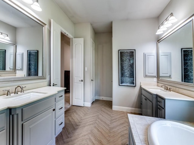 4400 Bristleleaf Ln, Prosper, TX 75078 - full bathroom with two vanities, baseboards, and a tub to relax in