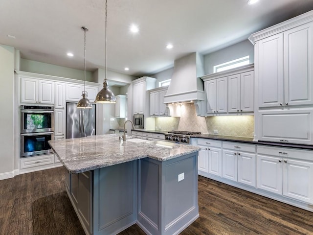 4400 Bristleleaf Ln, Prosper, TX 75078 - kitchen featuring stainless steel appliances, premium range hood, an island with sink, backsplash, and dark wood-style flooring