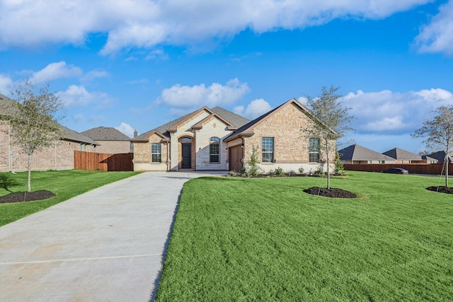 french country style house featuring brick siding, driveway, and an attached garage