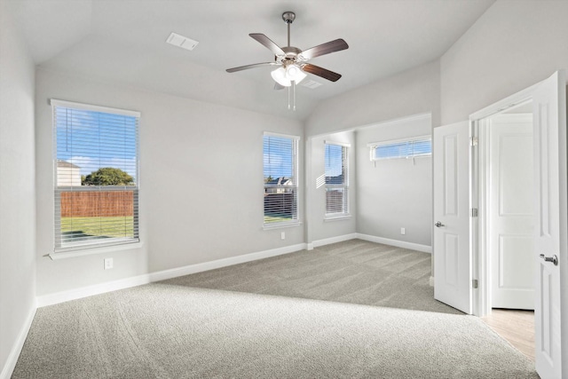 unfurnished bedroom with vaulted ceiling, light carpet, and baseboards