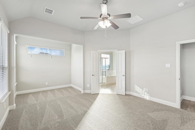 unfurnished bedroom featuring light carpet, lofted ceiling, baseboards, and a ceiling fan