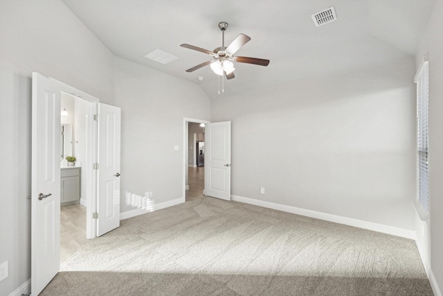 unfurnished bedroom with lofted ceiling, carpet flooring, baseboards, a ceiling fan, and connected bathroom