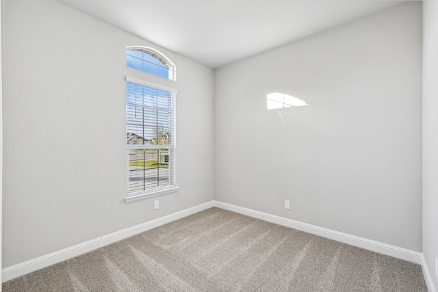 carpeted spare room with baseboards