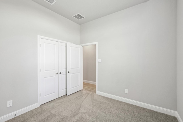 unfurnished bedroom featuring carpet flooring, baseboards, and a closet