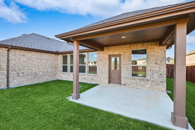 back of house featuring brick siding, a patio area, and a shingled roof