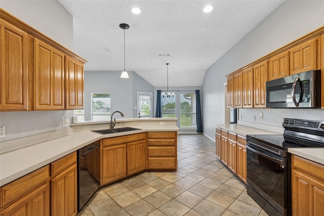 kitchen with black appliances, a sink, a textured ceiling, a peninsula, and plenty of natural light