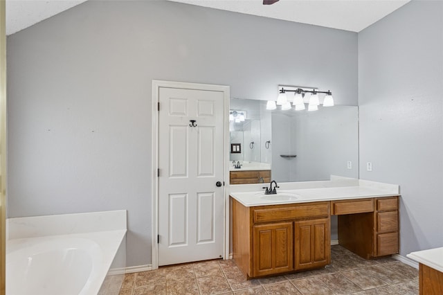 full bath featuring vanity, a garden tub, and baseboards