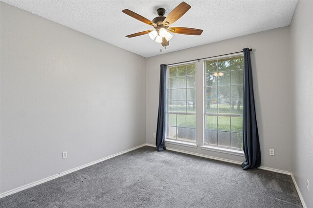 empty room with ceiling fan, carpet floors, baseboards, and a textured ceiling