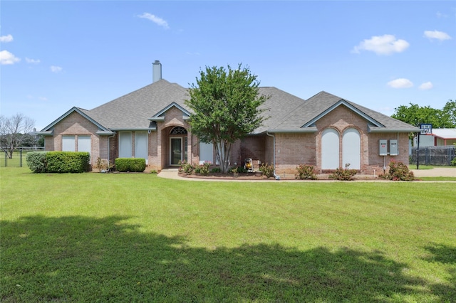 view of front of property featuring brick siding, roof with shingles, and a chimney