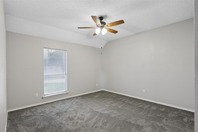 unfurnished room featuring a ceiling fan, dark colored carpet, a textured ceiling, and baseboards